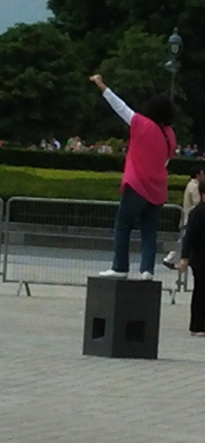 Woman standing on one of the sockets lifting her arm.