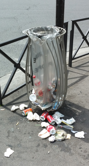 Broken bin with a lot of trash lying around.